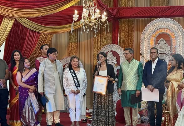 Staff member, Meghan Bedi, presenting Certification of Recognition to Bay Area Pabrasi commemorating Durga Puja