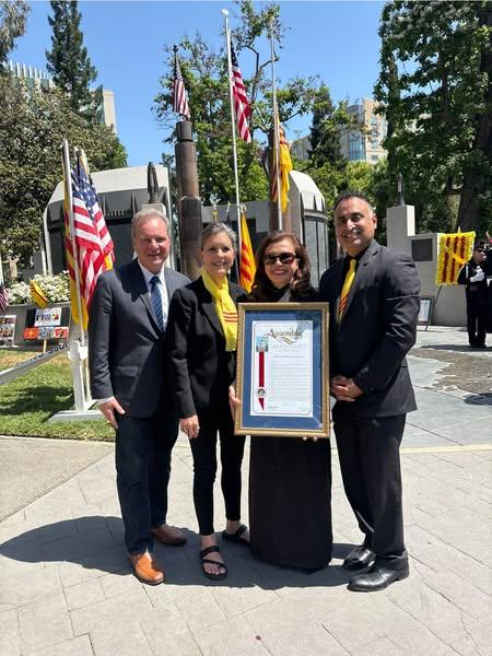 Senator Cortese, Pattie Cortese, Van Le, and Assemblymember Kalra, photographed with a resolution, surrounded by Vietnamese flags