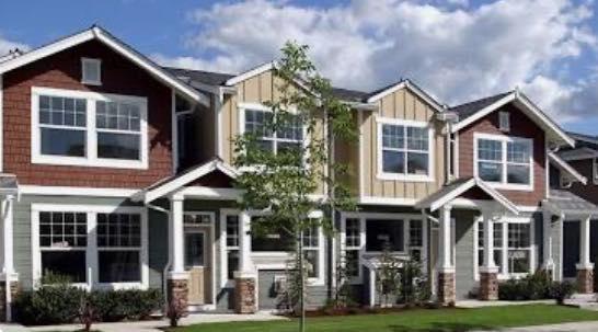 A line of four homes, alongside one another, photographed. 