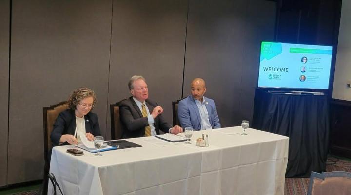 Senator Cortese photographed on a panel, speaking in between two other panel members.