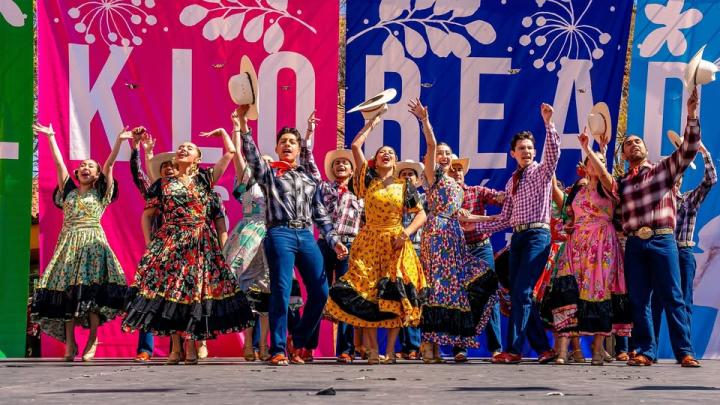 Image of community members dancing in traditional Mexican attire