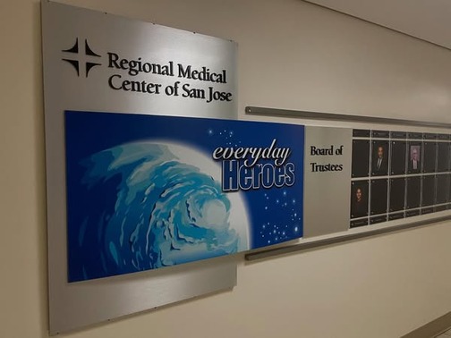 A commemorative plaque that reads “Regional Medical Center of San Jose,” “everyday heroes,” and “Board of Trustees” aside photos of trustees.
