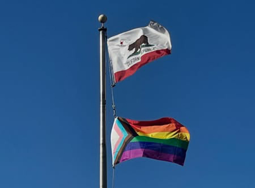 The California State flag and the Pride flag flying together