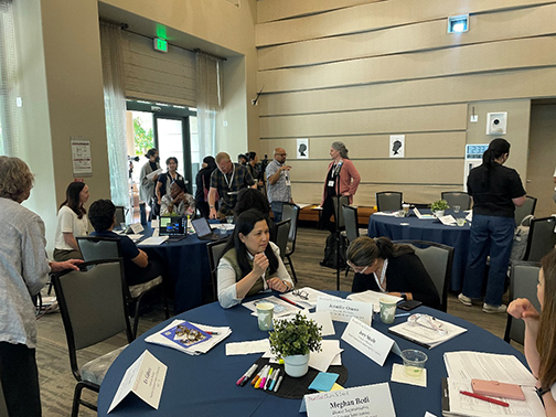 Group of educational professionals gathered in a conference room around tables 