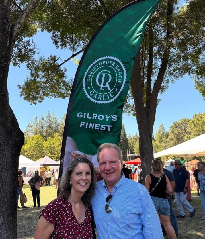 Senator Cortese and Pattie Cortese photographed in front of a Gilroy Garlic banner.