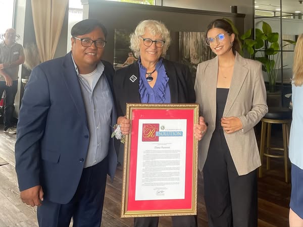 Staffers Mario Lopez and Meghan Bedi presenting a Resolution to Dana Bunnett