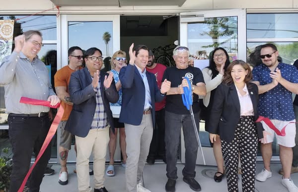 Staffer Mario Lopez, photographed among community leaders, at the Ribbon Cutting ceremony.