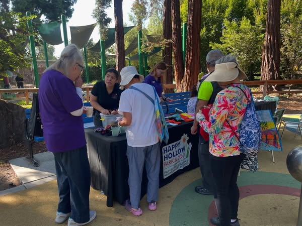 Seniors engaging in an activity at a Happy Hollow table.